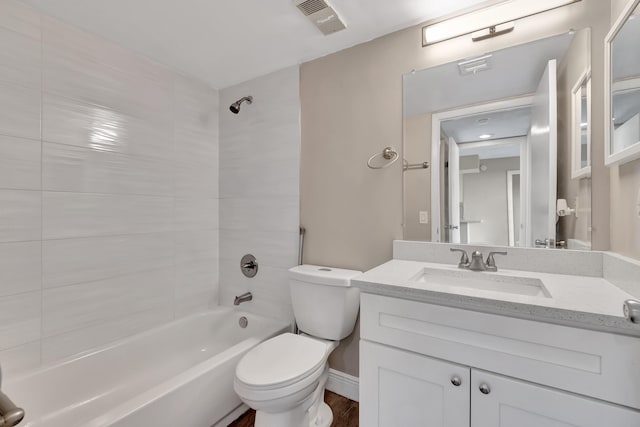 full bathroom featuring vanity, tiled shower / bath, hardwood / wood-style floors, and toilet