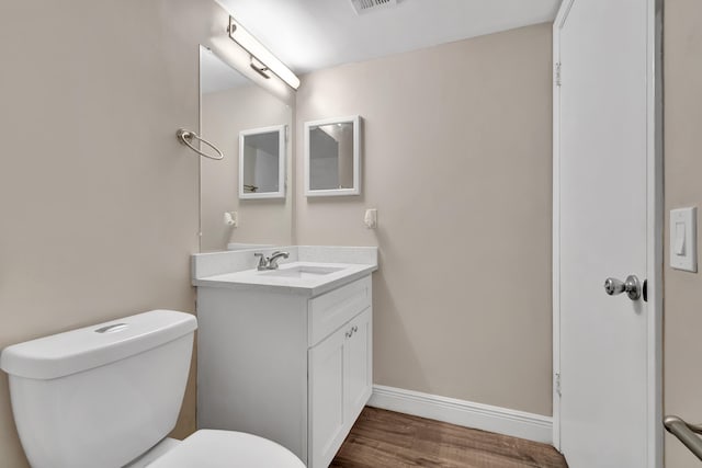 bathroom with toilet, hardwood / wood-style flooring, and vanity