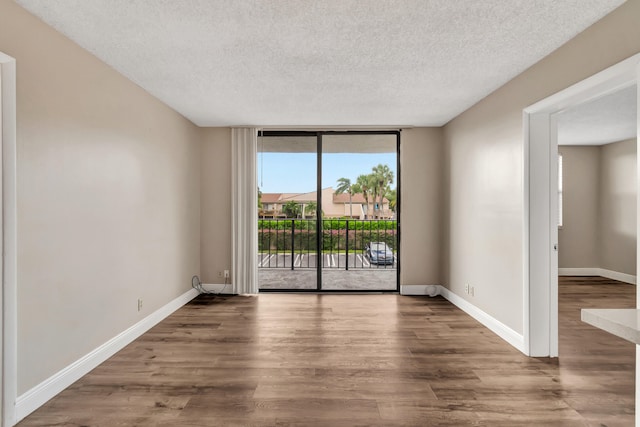 spare room featuring wood-type flooring and a textured ceiling