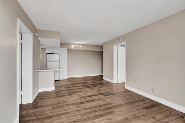 unfurnished living room with dark hardwood / wood-style floors