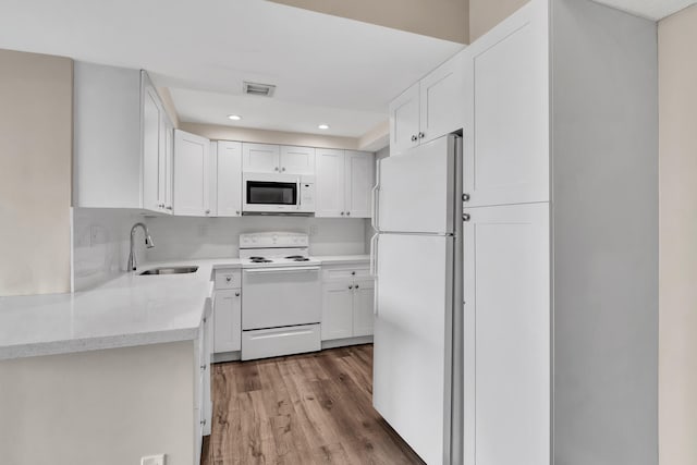 kitchen featuring white appliances, light hardwood / wood-style flooring, sink, and white cabinets