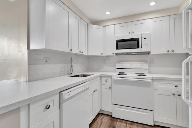 kitchen with dark wood-type flooring, white cabinets, and white appliances