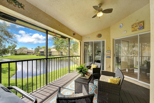 sunroom / solarium featuring ceiling fan, vaulted ceiling, and a water view