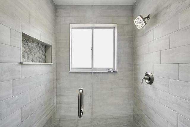 bathroom featuring a wealth of natural light and tiled shower