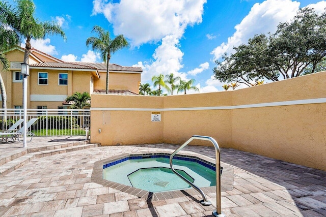 view of swimming pool with a hot tub and a patio area