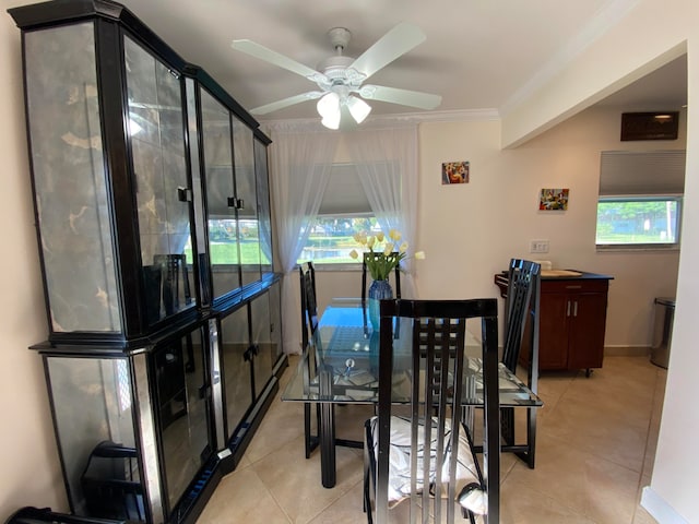 tiled dining room featuring ceiling fan and ornamental molding