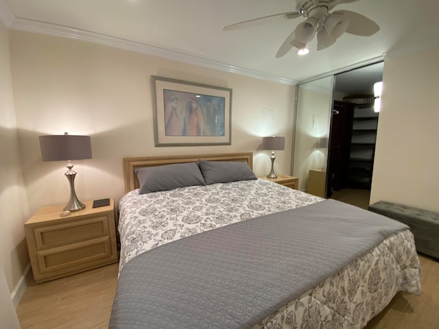 bedroom featuring ornamental molding, a closet, light hardwood / wood-style floors, and ceiling fan