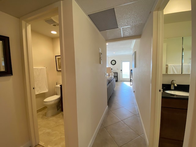 corridor with sink and light tile patterned floors