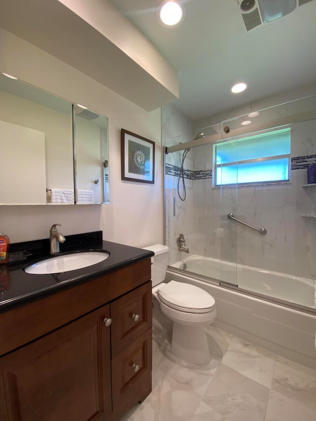 full bathroom featuring vanity, enclosed tub / shower combo, and toilet