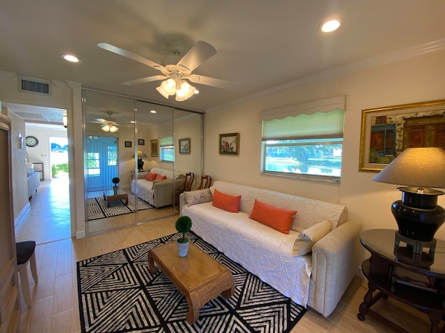 living room with light hardwood / wood-style floors, ceiling fan, a healthy amount of sunlight, and crown molding