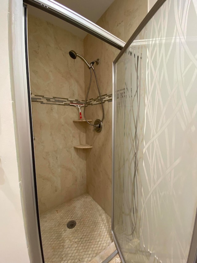 bathroom with a shower with door