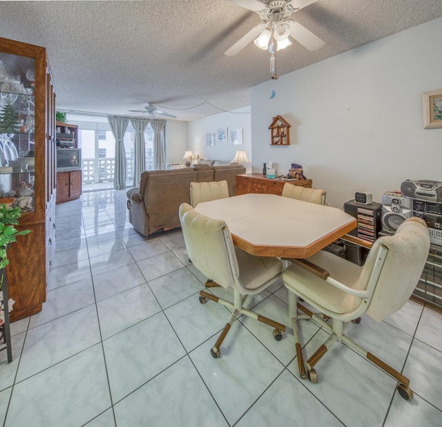 tiled dining room with a textured ceiling and ceiling fan