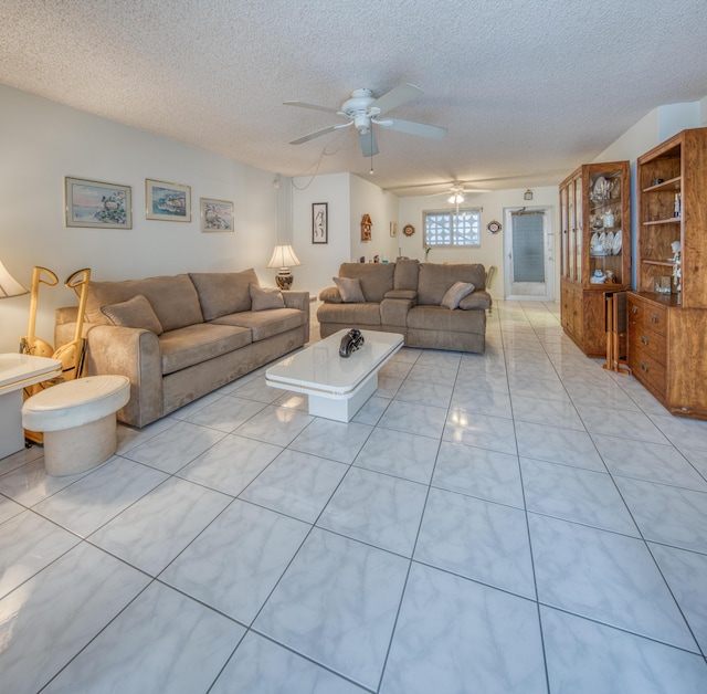 living room featuring ceiling fan, light tile patterned floors, and a textured ceiling