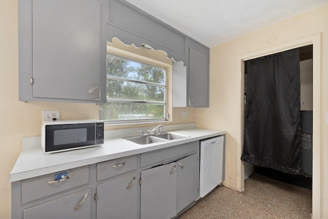 kitchen featuring white dishwasher, gray cabinetry, and sink