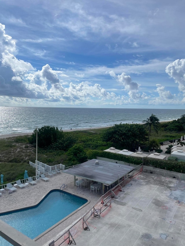 view of swimming pool with a patio and a water view