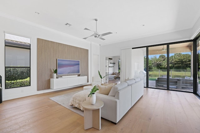 living room featuring ceiling fan, ornamental molding, and light hardwood / wood-style flooring