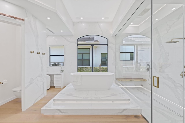 full bathroom with separate shower and tub, a wealth of natural light, wood-type flooring, and toilet