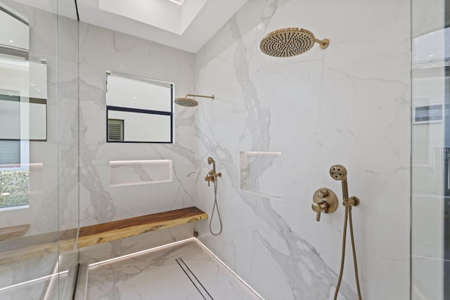 bathroom with tiled shower and a skylight