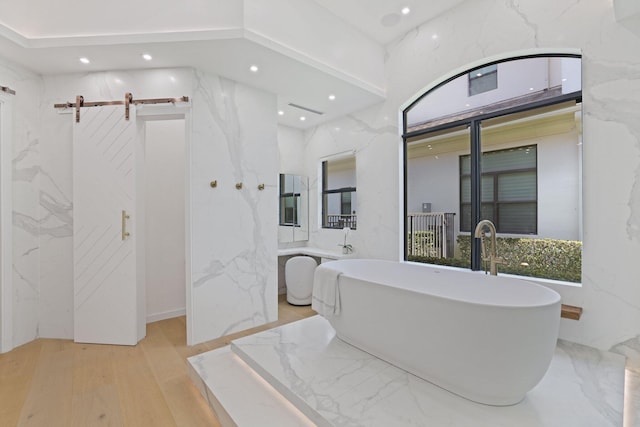 bathroom with hardwood / wood-style flooring and a tub