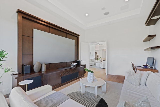 living room with a raised ceiling and light hardwood / wood-style flooring