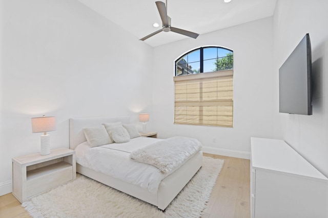 bedroom with ceiling fan, light wood-type flooring, and lofted ceiling