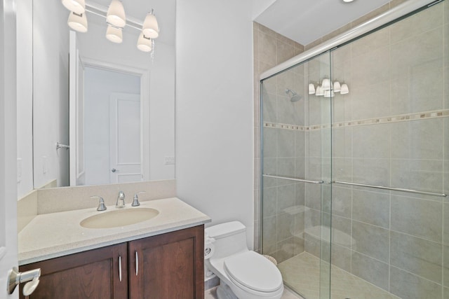 bathroom with vanity, an enclosed shower, and toilet