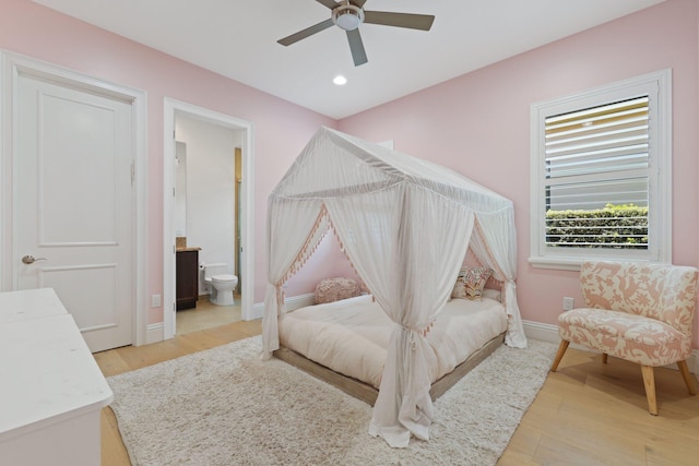 bedroom with ensuite bathroom, ceiling fan, and light hardwood / wood-style flooring