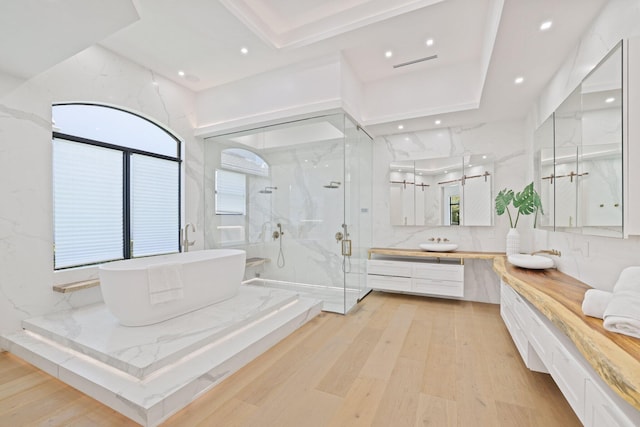 bathroom featuring hardwood / wood-style floors, vanity, and plus walk in shower