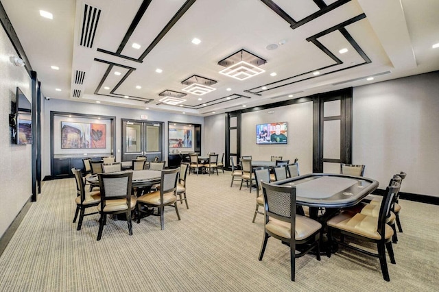 dining area with a raised ceiling and light carpet