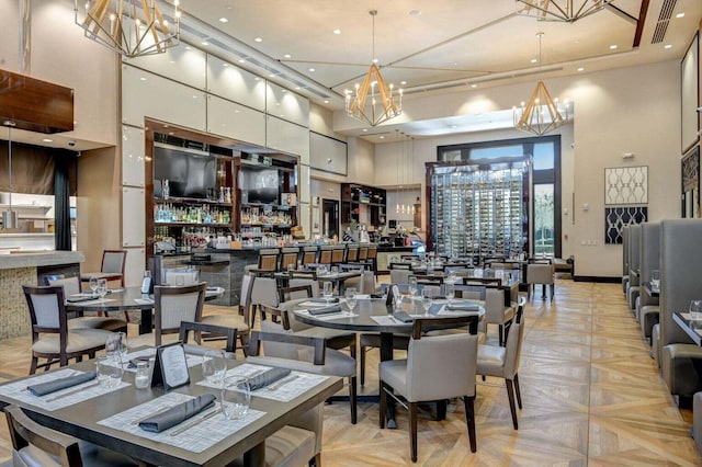 dining room featuring a high ceiling and light parquet flooring