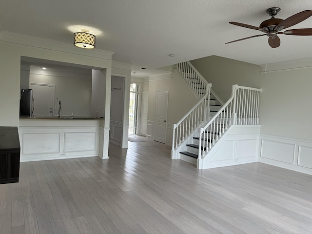 entrance foyer featuring ceiling fan, a textured ceiling, and light hardwood / wood-style flooring