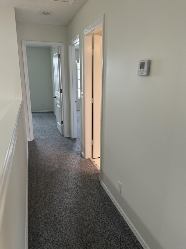 corridor with dark colored carpet