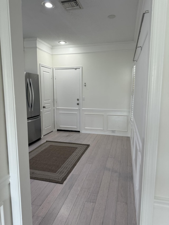 hallway featuring light hardwood / wood-style flooring and crown molding