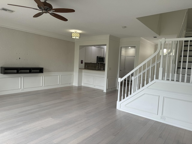 unfurnished living room with light wood-type flooring and ceiling fan