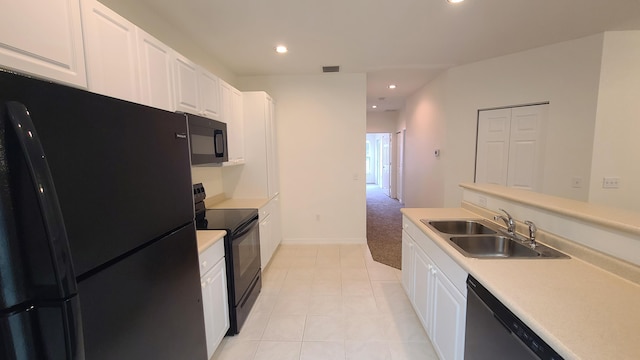 kitchen featuring black appliances, sink, light tile patterned floors, and white cabinets