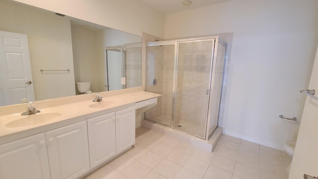bathroom with tile patterned floors, toilet, a stall shower, and a sink