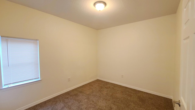 carpeted spare room with baseboards