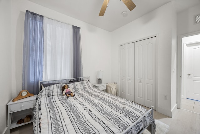 bedroom with light hardwood / wood-style floors, a closet, and ceiling fan