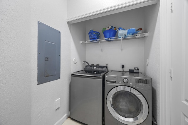 clothes washing area featuring electric panel and washing machine and dryer