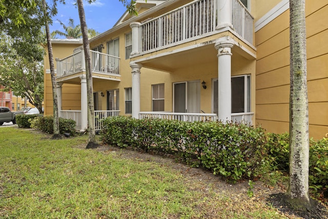 exterior space featuring a balcony and a yard