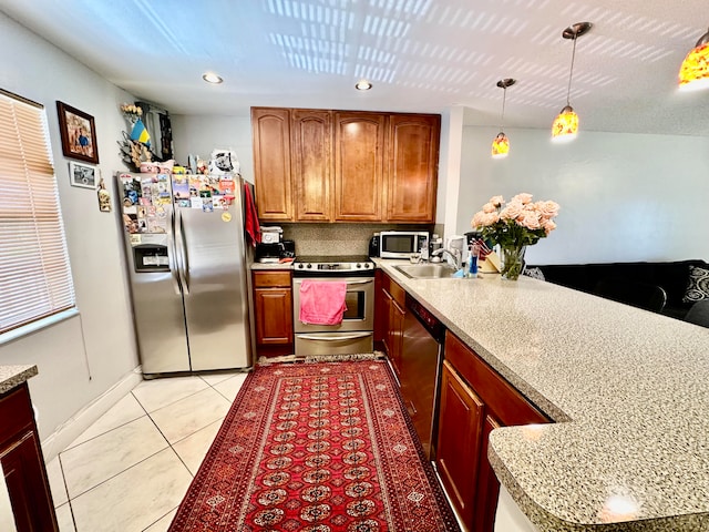 kitchen featuring appliances with stainless steel finishes, sink, light tile patterned floors, and decorative light fixtures