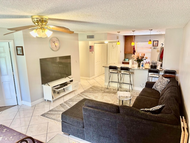 tiled living room featuring ceiling fan and a textured ceiling