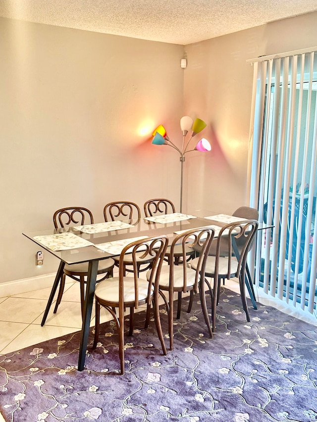 dining area with a textured ceiling and tile patterned flooring