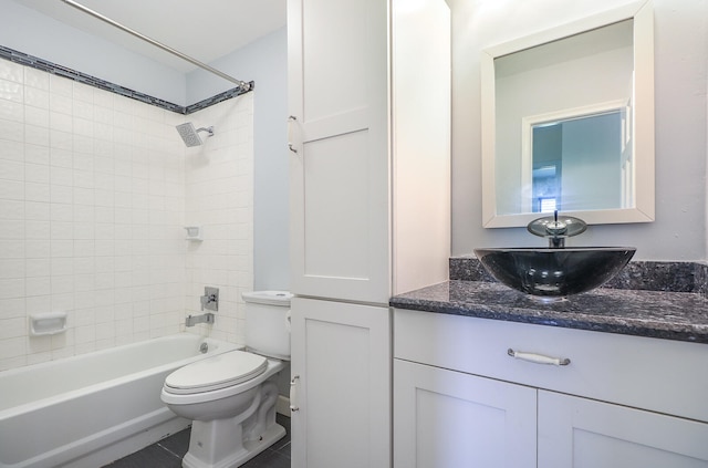 full bathroom featuring tiled shower / bath, tile patterned floors, vanity, and toilet