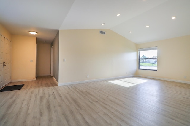 empty room with lofted ceiling and light hardwood / wood-style flooring