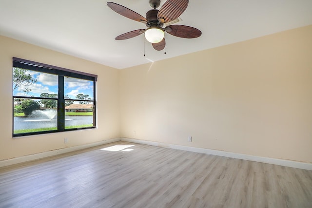 unfurnished room featuring ceiling fan, a water view, and light hardwood / wood-style flooring