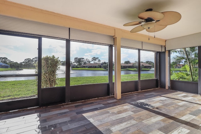 unfurnished sunroom with a water view and ceiling fan