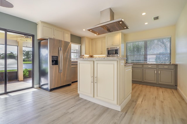 kitchen featuring light wood-type flooring, stainless steel appliances, and light stone counters