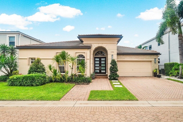 mediterranean / spanish-style house featuring a front yard and a garage