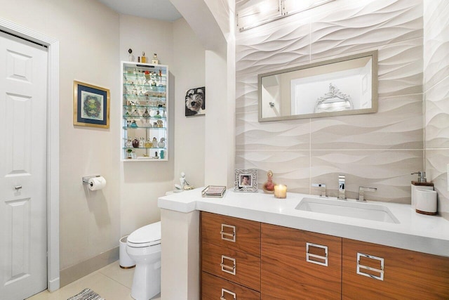 bathroom with vanity, toilet, tile patterned flooring, and backsplash